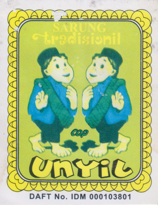 [Fig.2] This printed paper label from the Grafis Nusantara Collection features the Sarung Tradisional, Cap Unyil. The design includes two mirrored cartoon boys in pecis, each with a sarung slung across their shoulders, greeting or praying. The label references Si Unyil, a beloved puppet hero from a children's television series, connecting the garment to a character familiar to many Indonesian families.